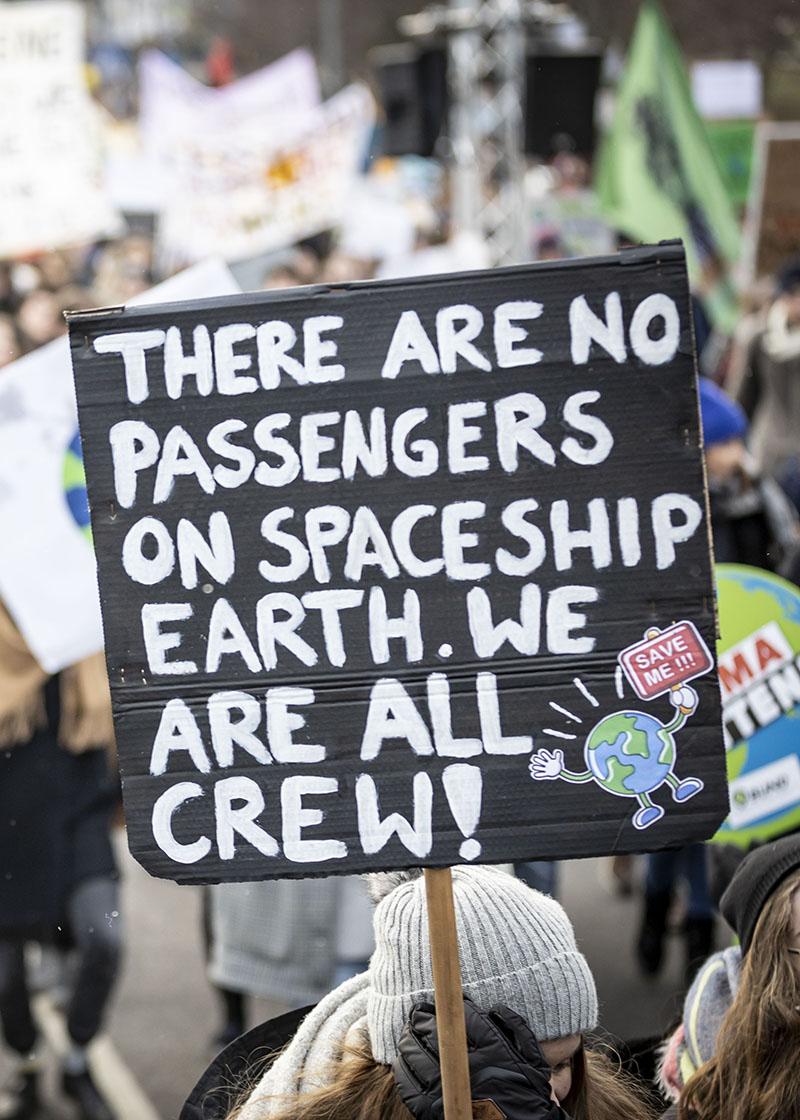 Demoschild mit Aufschrift There are no passengers on spaceship earth. We are all crew