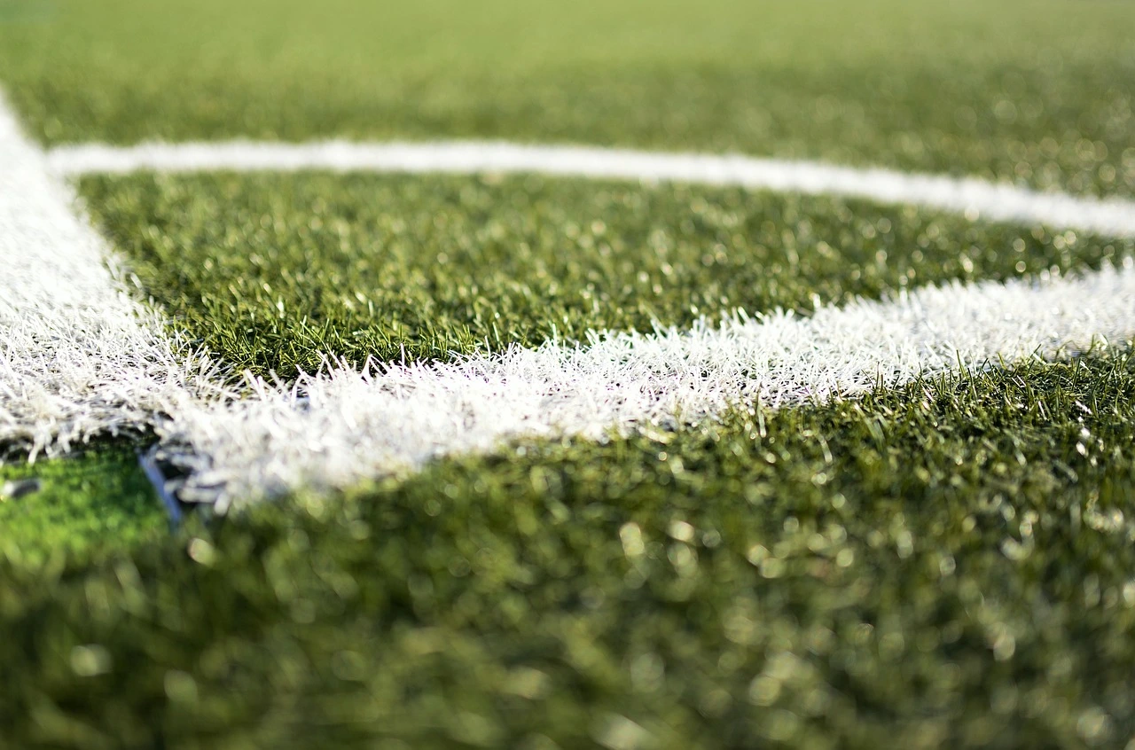 Das Foto zeigt eine Nahaufnahme eines Fußballplatzes mit weißer Markierung.