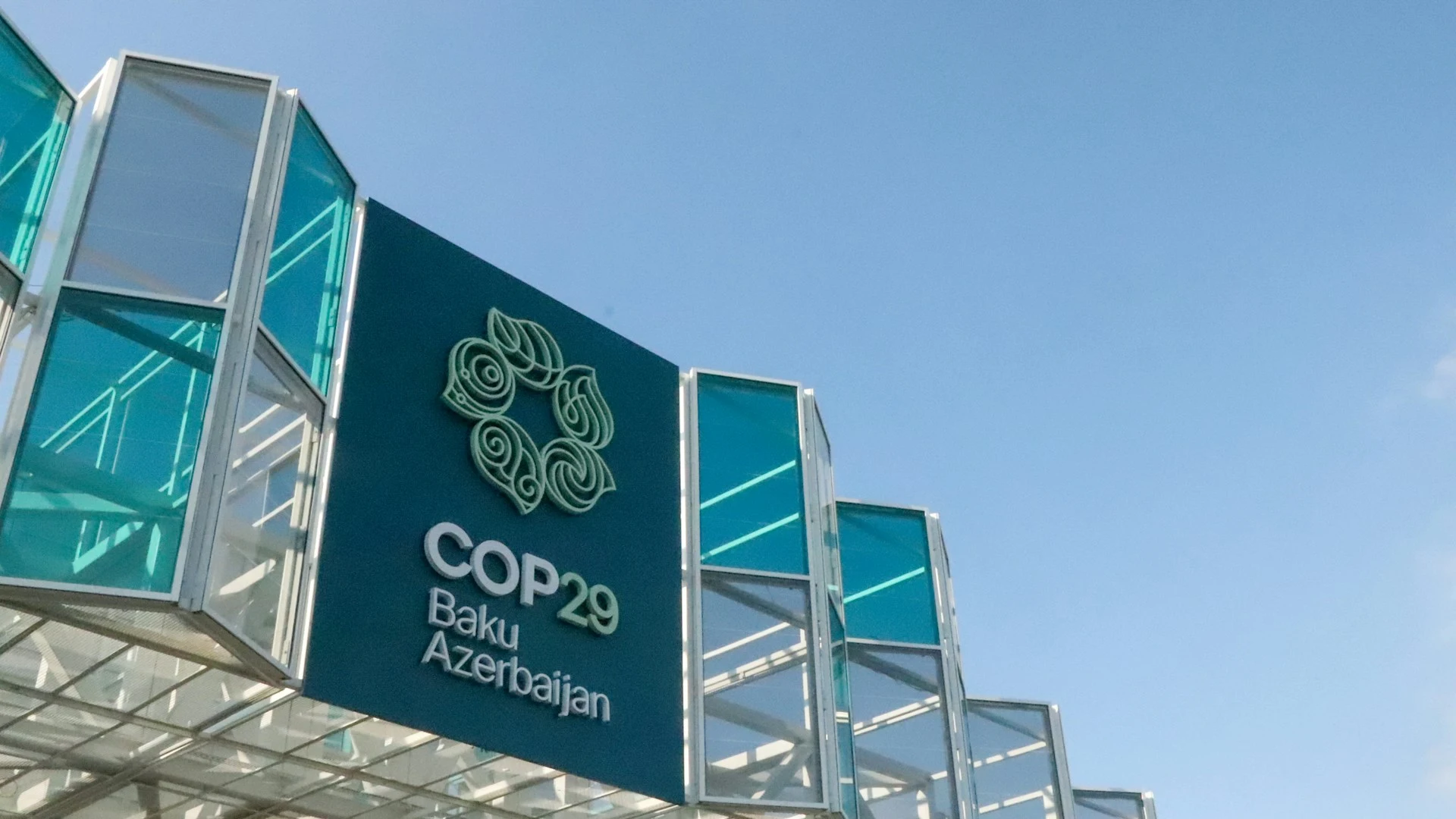 Das Foto zeigt ein bläuliches Gebäude mit dem Log der COP29.