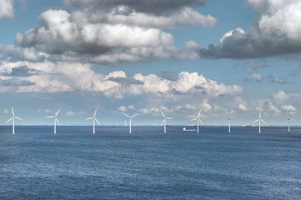 Das Foto zeigt mehrere Windkrafträder im Meer.