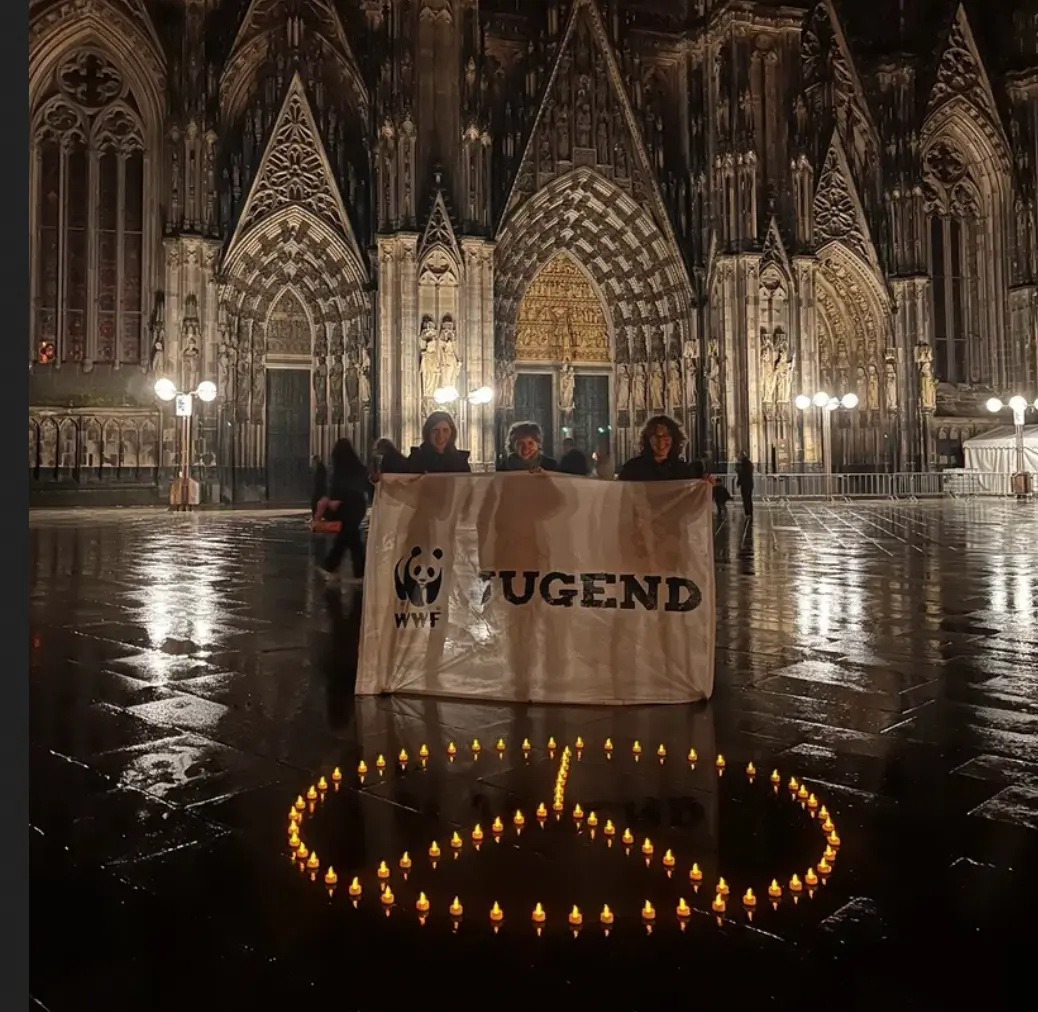 WWF Jugend-Gruppe mit Friedenssymbol aus Kerzen vor dem Kölner Dom © M. Kopetzky