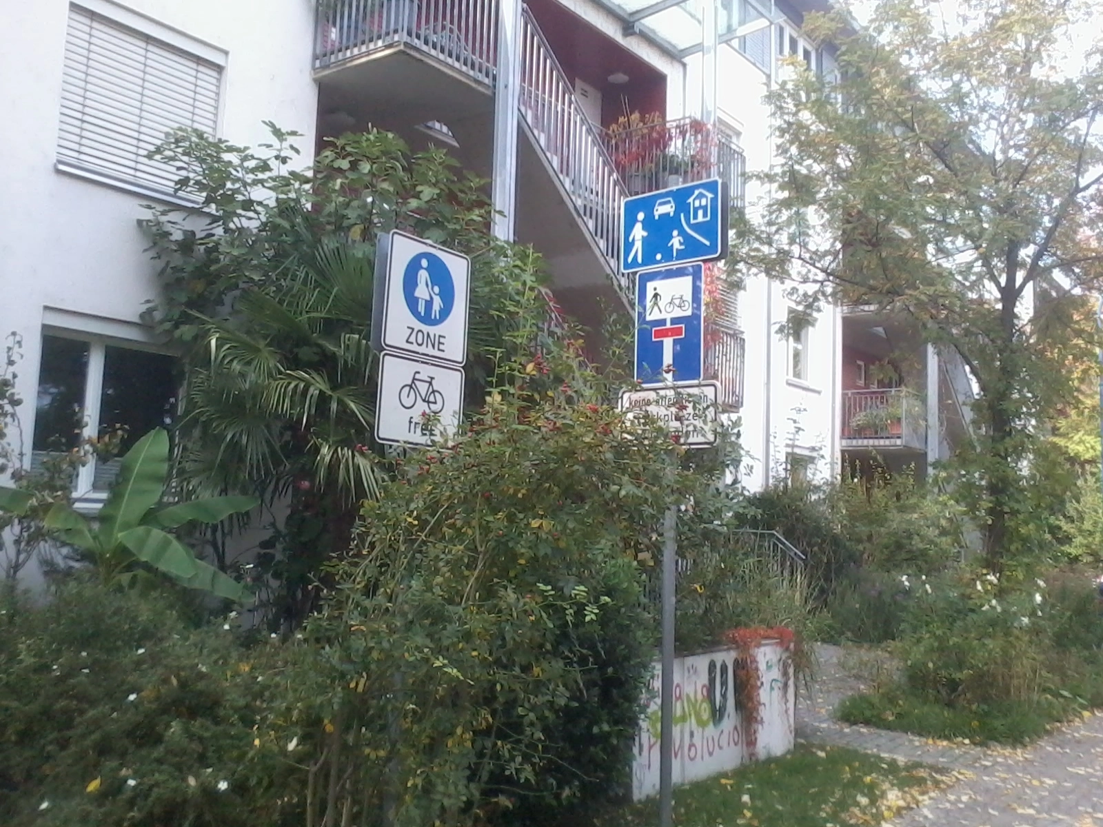 Das Foto zeigt die Verkehrsschilder "Fußgängerzone" und "Spielstraße" in einem Wohngebiet.