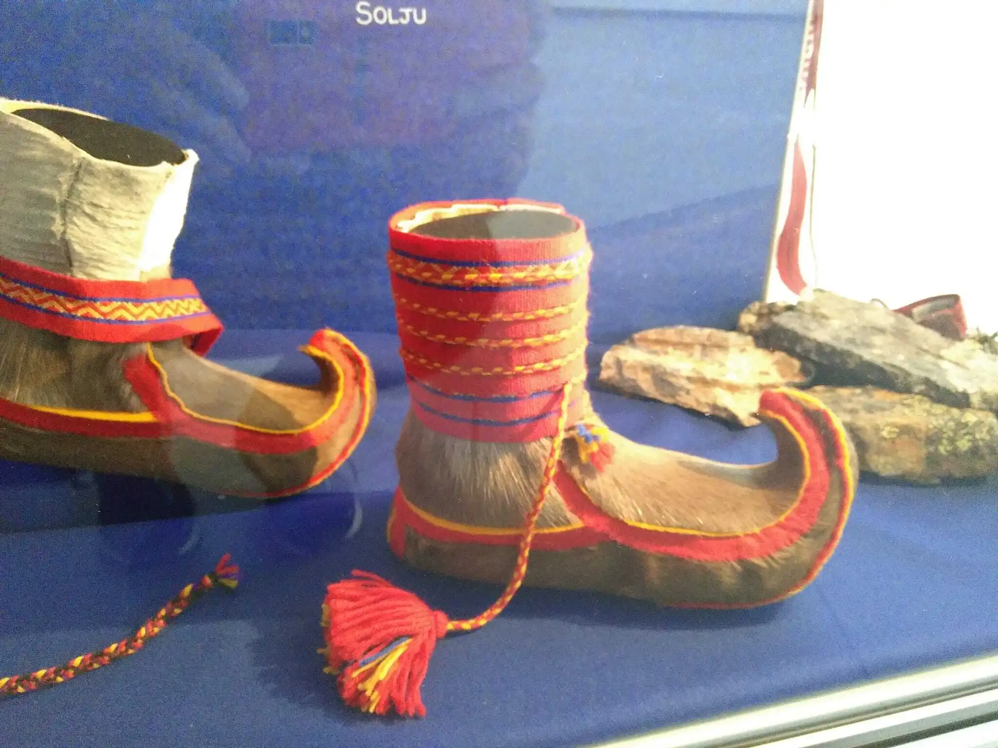 Das Bild zeigt einen Schuh der zu traditionellen Tracht eines Sami-Stamms gehört. Die Spitze ist nach oben gebogen, so konnte der Schuh vorne in eine Schlaufe am Ski eingeharkt werden.