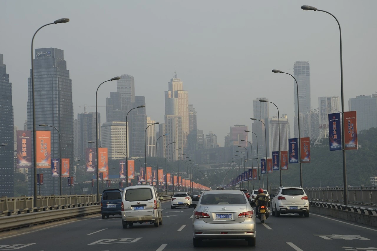 Eine asiatische Stadt mit Hochhäusern, Verkehr und deutlicher Luftverschmutzung