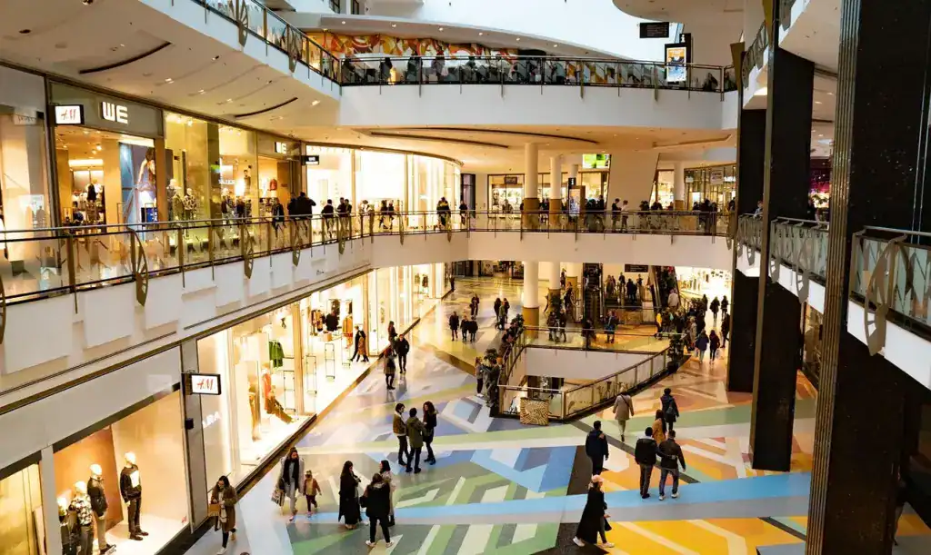 ein hell beleuchtetes Shoppingzentrum mit vielen Menschen
