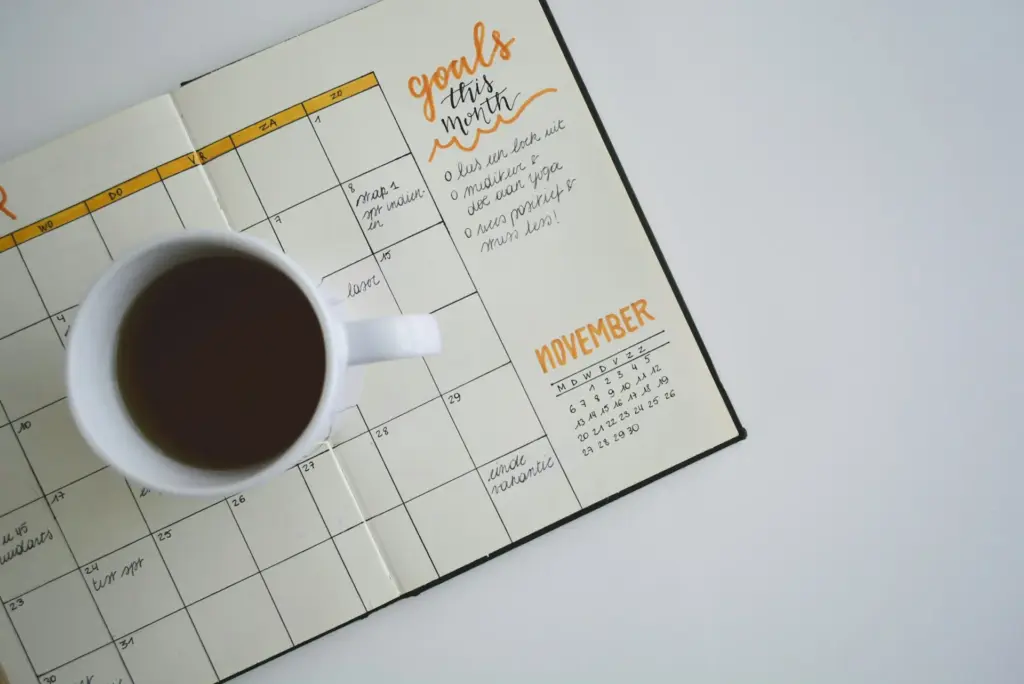 Eine Kaffetasse auf einem aufgeschlagenen Monatsplaner
