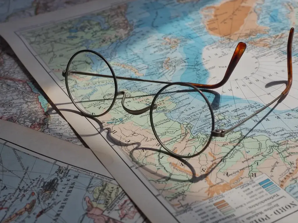 eine Brille liegt auf mehreren Landkarten