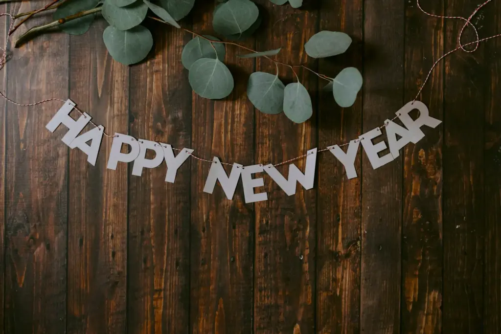 Eine Girlande mit dem Schriftzug "Happy New Year" auf einer Fläche aus Holz