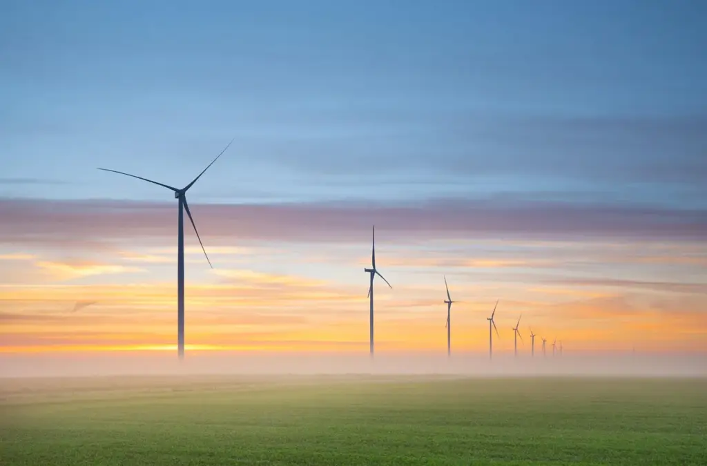 eine Landschaftsaufnahme mit einer Reihe Windrädern