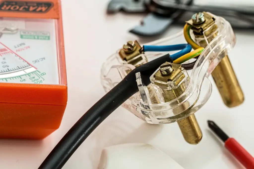Ein Teil eines Elektrogeräts mit Kabeln, Schrauben und Werkzeug