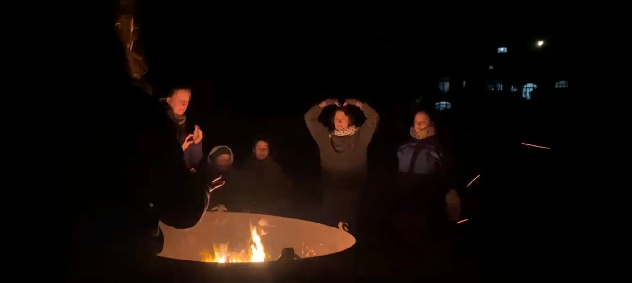 Zweite Begegnung mit dem Fuchs: Er hat doch tatsächlich unseren Snack gestohlen!! Es ist dunkel. Jugendliche sitzen um ein Lagerfeuer.